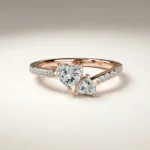 Heart-shaped dual-stone asymmetric bypass lab grown diamond engagement ring with approximately 0.75 ct total diamonds and pavé shoulders in rose gold.